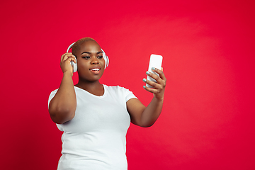 Image showing African-american young woman\'s portrait on red background