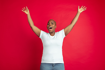 Image showing African-american young woman\'s portrait on red background