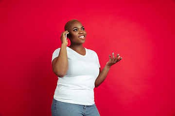 Image showing African-american young woman\'s portrait on red background