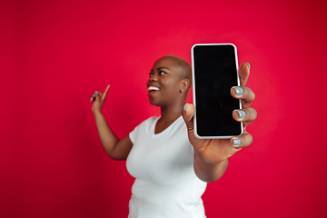 Image showing African-american young woman\'s portrait on red background