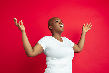 Image showing African-american young woman\'s portrait on red background