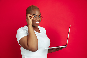 Image showing African-american young woman\'s portrait on red background