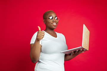 Image showing African-american young woman\'s portrait on red background