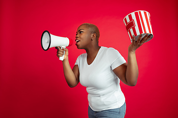 Image showing African-american young woman\'s portrait on red background