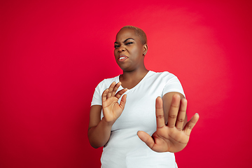 Image showing African-american young woman\'s portrait on red background