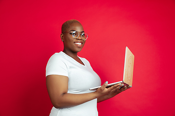 Image showing African-american young woman\'s portrait on red background