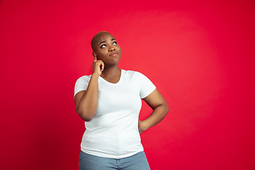 Image showing African-american young woman\'s portrait on red background