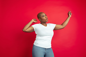 Image showing African-american young woman\'s portrait on red background