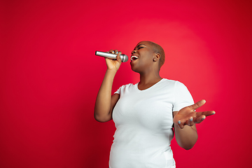 Image showing African-american young woman\'s portrait on red background