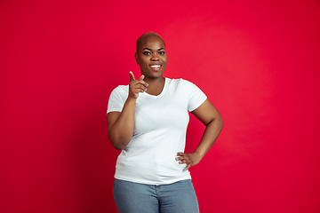 Image showing African-american young woman\'s portrait on red background