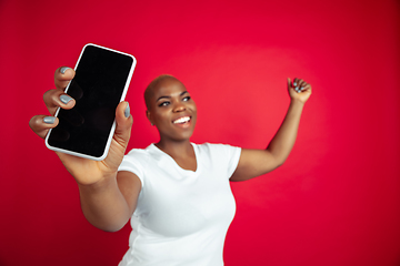 Image showing African-american young woman\'s portrait on red background