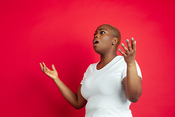 Image showing African-american young woman\'s portrait on red background