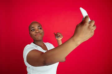 Image showing African-american young woman\'s portrait on red background