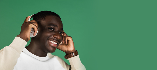 Image showing African man\'s portrait isolated on green studio background with copyspace