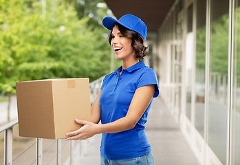 Image showing happy delivery girl with parcel box in blue