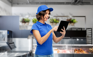 Image showing happy smiling delivery girl with tablet pc at shop