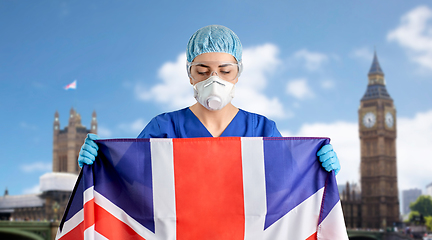 Image showing doctor in goggles and mask holding flag of england