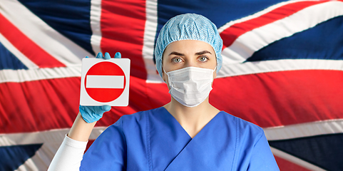 Image showing british doctor or nurse in mask showing stop sign