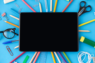 Image showing tablet pc and school supplies on blue background