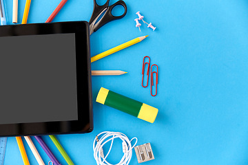 Image showing tablet pc and school supplies on blue background