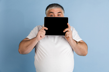 Image showing Handsome caucasian plus size male model isolated on blue studio background. Concept of inclusion, human emotions, facial expression