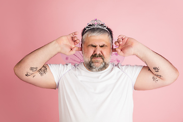 Image showing Handsome caucasian plus size male model isolated on coral pink studio background. Concept of inclusion, human emotions, facial expression