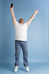 Image showing Handsome caucasian plus size male model isolated on blue studio background. Concept of inclusion, human emotions, facial expression