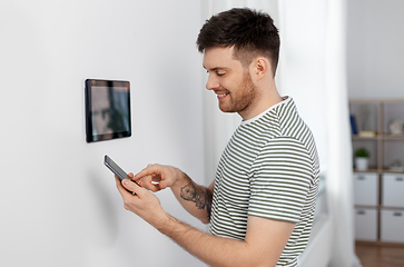 Image showing smiling man using tablet computer at smart home