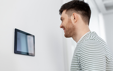 Image showing happy man looking at tablet computer at smart home