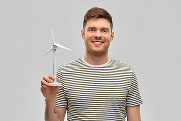 Image showing smiling young man with toy wind turbine