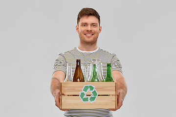 Image showing smiling young man sorting glass waste