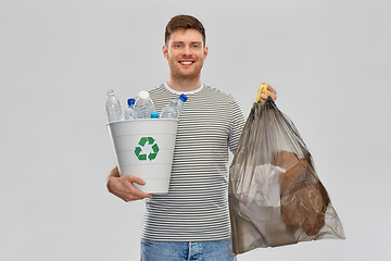 Image showing smiling man sorting paper and plastic waste