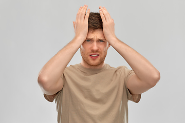 Image showing unhappy man suffering from headache