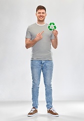 Image showing smiling young man holding green recycling sign