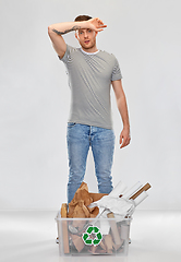 Image showing tired young man sorting paper waste