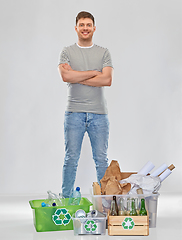 Image showing smiling man sorting paper, metal and plastic waste