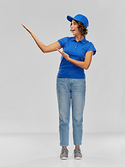 Image showing happy smiling delivery woman in blue uniform