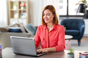 Image showing happy woman with laptop working at home office