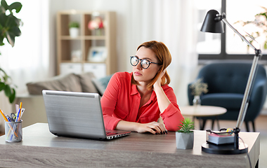 Image showing bored woman with laptop working at home office