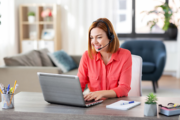 Image showing woman with headset and laptop working at home