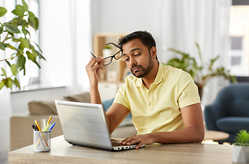 Image showing bored man with laptop working at home office