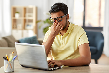 Image showing tired man with laptop working at home office