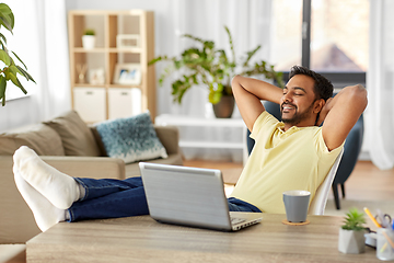 Image showing man with laptop and feet on table at home office