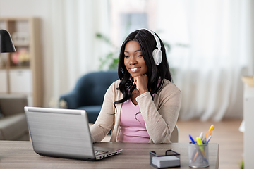 Image showing woman in headphones with laptop working at home