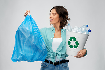 Image showing smiling woman sorting plastic waste and trash bag