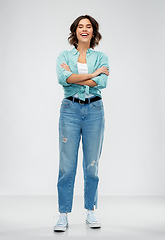 Image showing smiling young woman in turquoise shirt and jeans