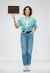 Image showing portrait of smiling woman showing black chalkboard