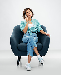 Image showing woman sitting in chair and calling on smartphone