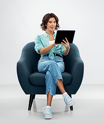 Image showing happy woman with tablet pc sitting in armchair