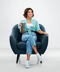 Image showing woman sitting in chair with cup of coffee or tea